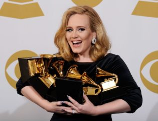Adele posing with her Grammy Awards